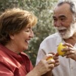 Older couple toasting the day with orange juice while sitting out among the trees