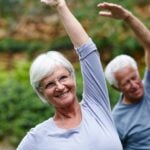 Mature individuals participating in yoga outside