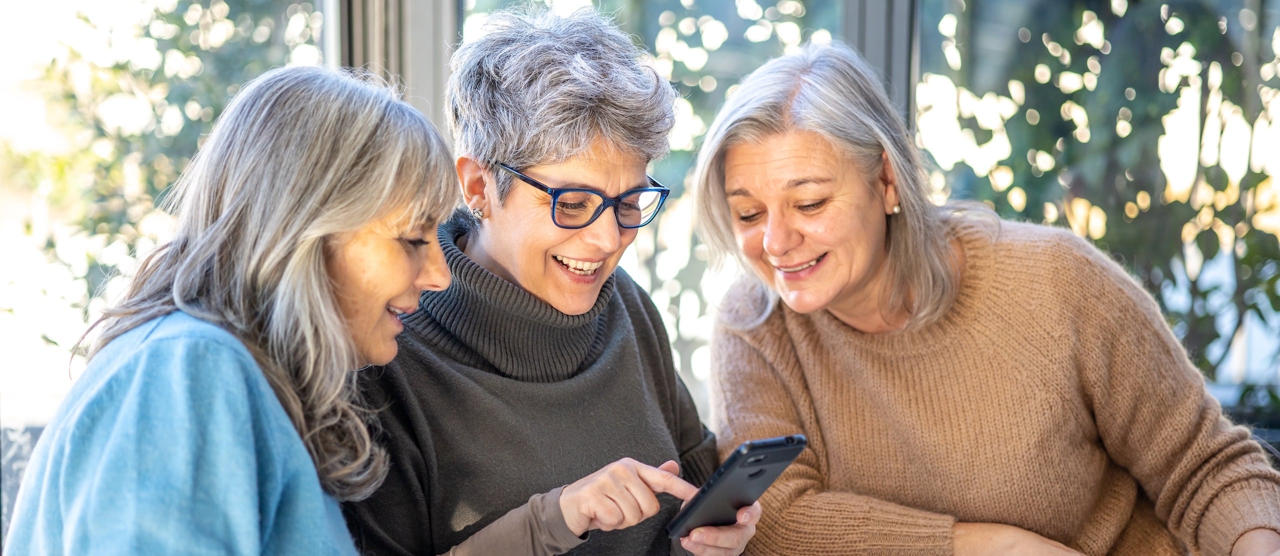 Three women looking at a phone
