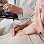 Two elderly people looking over an ipad together, one person seems to be going over it